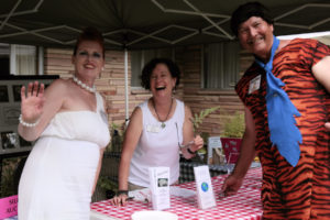 Fred and Wilma Flintstone pose with volunteer Barb Epstein at Silent Auction Booth.