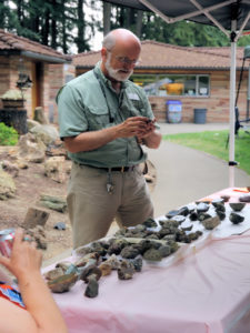 Executive Director Julian Gray checks out the rocks at Summer Fest vendor booth.