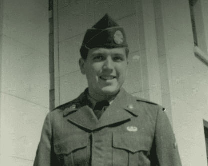 A man dressed in an American military uniform smiling at the camera.